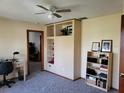 Bedroom with ceiling fan, built in shelving unit, and adjacent desk area at 22116 26Th E Ave, Bradenton, FL 34211