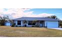 Charming single-story home featuring a well-manicured lawn, a two-car garage, and a quaint detached garage at 22116 26Th E Ave, Bradenton, FL 34211