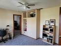 Bright office space with a built-in bookshelf, neutral paint, and a ceiling fan for added comfort at 22116 26Th E Ave, Bradenton, FL 34211