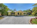 Charming yellow bungalow with a gravel driveway and tropical landscaping at 2332 Alameda Ave, Sarasota, FL 34234