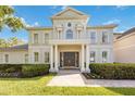 Close-up view of a home's entrance featuring columns, a double door, manicured shrubs and landscaping at 340 Osprey Point Dr, Osprey, FL 34229
