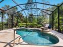 A beautiful screened-in pool and spa area with a lounge chair for relaxing by the water at 355 Melrose Ct, Venice, FL 34292