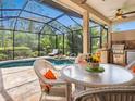 Inviting screened-in patio features a pool, spa, dining area, and an outdoor kitchen, perfect for entertaining at 355 Melrose Ct, Venice, FL 34292