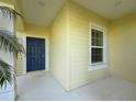Welcoming entryway with blue front door, decorative window, and pale yellow siding at 3706 Shimmering Oaks Dr, Parrish, FL 34219