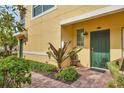 Inviting entryway with brick path and green door and nice landscaping at 4236 Expedition Way # 106, Osprey, FL 34229