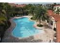 Expansive community pool featuring clear blue water, ample lounge seating, and lush tropical surroundings at 4236 Expedition Way # 106, Osprey, FL 34229