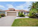 Charming single-story home with a red tile roof, attached two-car garage and inviting, well-maintained lawn at 4961 Sabal Lake Cir, Sarasota, FL 34238