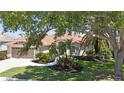 Well-maintained home with lush landscaping and a curved walkway to the front door at 4961 Sabal Lake Cir, Sarasota, FL 34238