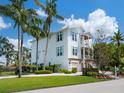 Beautiful two-story home with covered parking, complemented by vibrant landscaping and lush greenery at 497 Island Cir, Sarasota, FL 34242
