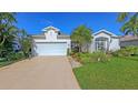 Inviting one-story home showcasing a two-car garage, vibrant landscaping, and a well-maintained lawn at 5022 46Th W St, Bradenton, FL 34210