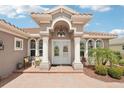 Inviting front entrance with columns, decorative windows, and a brick walkway leading to double doors at 5480 White Ibis Dr, North Port, FL 34287
