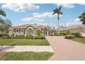 Beautiful home with lush green lawn, a palm tree, and a paved brick driveway leading up to the entrance at 5480 White Ibis Dr, North Port, FL 34287