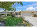 Charming single-story home with a well-manicured lawn and attached two-car garage at 5623 Palm Aire Dr, Sarasota, FL 34243
