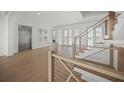 Bright foyer features wood floors, a staircase with stainless steel railing, and an elevator at 619 Key Royale Dr, Holmes Beach, FL 34217
