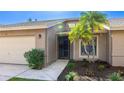 Inviting front entry showcasing a well-kept lawn, a two-car garage and beautiful exterior lighting at 620 49Th E St, Bradenton, FL 34208