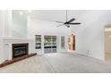 Spacious living room with fireplace, bright carpet, ceiling fan, and sliding glass doors to an outside patio at 620 49Th E St, Bradenton, FL 34208