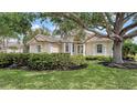 Elegant home with lush lawn, mature trees, and manicured hedges creates inviting curb appeal at 7319 Westminster Ct, University Park, FL 34201
