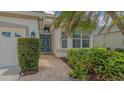 Elegant blue double doors lead to a welcoming entrance with manicured shrubs at 8263 Nice Way, Sarasota, FL 34238