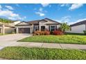 Attractive one-story home featuring a well-manicured lawn, colorful landscaping, and a two-car garage at 11092 58Th Street Cir E, Parrish, FL 34219