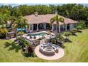 Aerial view showcasing a backyard with a pool, patio seating, and a fire pit, perfect for outdoor entertaining at 12224 Garden Lake Cir, Odessa, FL 33556