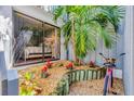 Charming patio area with lush garden, complemented by a sliding glass door into the home at 1235 Dockside Place # 108, Sarasota, FL 34242