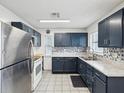 Modern kitchen with stainless steel appliances, blue cabinets, and decorative backsplash at 13241 Miami St, Hudson, FL 34667