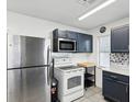 This kitchen features stainless steel appliances and blue cabinets with modern hardware at 13241 Miami St, Hudson, FL 34667