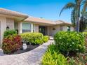 Charming front entrance with decorative landscaping leading to the front door and a stone tile walkway at 142 Dory Ln, Osprey, FL 34229