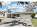 Inviting single-story home with a lush lawn, two-car garage, and a cozy front porch area at 1440 S Keene Rd, Clearwater, FL 33756