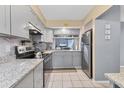 Modern kitchen with gray cabinets, stainless steel appliances, granite countertops, and tile flooring at 1533 42Nd Avenue E Dr # 48, Ellenton, FL 34222