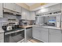Modern kitchen with gray cabinets, stainless steel appliances, granite countertops, and tile flooring at 1533 42Nd Avenue E Dr # 48, Ellenton, FL 34222