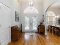 Elegant foyer with hardwood floors, decorative lighting, and arched doorway leading to dining room at 1860 Citron St, Punta Gorda, FL 33980
