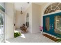Inviting front porch with rocking chairs, decorative tile flooring, and a vibrant teal front door at 1860 Citron St, Punta Gorda, FL 33980