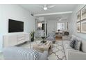 Bright living room featuring modern furnishings, a ceiling fan, and an open layout to the dining area and kitchen at 2227 Sunset Dr # E22, Bradenton, FL 34207