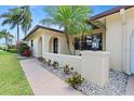 Charming home with a courtyard entry, stucco wall and tropical landscaping detail at 2301 Arborfield Ln, Sarasota, FL 34235