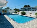Inviting swimming pool with clear blue water, surrounded by a paved deck and manicured landscaping at 2605 Sunnybrook Dr, Sarasota, FL 34239
