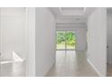 Hallway with tile floors, tray ceiling, and sliding glass doors to the backyard at 27407 Deep Creek Blvd, Punta Gorda, FL 33983
