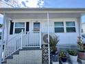 Charming single-story home featuring an inviting front porch with white railings and well-maintained landscaping at 3710 Gulf Of Mexico Dr # E22, Longboat Key, FL 34228