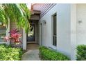 Close-up of the home's front entrance surrounded by lush landscaping, bushes, and a tiled walkway at 3954 Wilshire Cir # 165, Sarasota, FL 34238