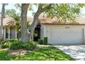 Charming single-story home with a one-car garage, a well-manicured lawn, mature trees, and lush landscaping at 3954 Wilshire Cir # 165, Sarasota, FL 34238