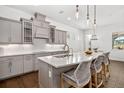 Bright kitchen boasts sleek gray cabinets, pendant lighting, stainless appliances, and a marble countertop island at 4712 Margutta Ct, Sarasota, FL 34240