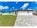 Beautifully landscaped home with a spacious three-car garage and a stylish paver driveway at 5322 Syracuse Rd, Venice, FL 34293