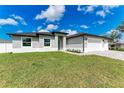 This home features a spacious three-car garage, fresh landscaping, and a sprawling green lawn at 5322 Syracuse Rd, Venice, FL 34293