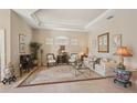 Elegant living room featuring tray ceilings, tile floors, and classic furnishings at 5412 Royal Poinciana Way, North Port, FL 34291