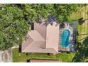 Aerial view of a home featuring a screened-in pool and lush surrounding trees at 5712 Garden Lakes Fern, Bradenton, FL 34203