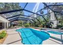 An inviting screened-in pool with a hot tub offers a private backyard retreat at 5712 Garden Lakes Fern, Bradenton, FL 34203