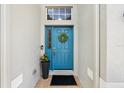 Stylish blue front door adorned with a wreath, complemented by a decorative flower pot at 5907 90Th Avenue E Cir, Parrish, FL 34219