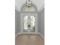 Bright foyer featuring double doors with decorative glass and light hardwood floors at 600 Eagle Watch Ln, Osprey, FL 34229