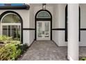 Elegant front entryway with arched windows and double doors flanked by white columns at 600 Eagle Watch Ln, Osprey, FL 34229