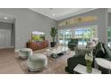 Bright living room with large windows overlooking the pool area, hardwood floors, and comfortable seating at 600 Eagle Watch Ln, Osprey, FL 34229